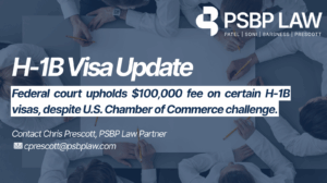 A professional legal update graphic from PSBP Law announcing an H-1B visa update, highlighting that a federal court upheld a $100,000 fee on certain H-1B visas despite a U.S. Chamber of Commerce challenge. The image features a blue corporate background, an overhead view of business professionals in white shirts gathered around a table holding pencils, and PSBP Law branding with contact information for a law partner, emphasizing immigration law, compliance, and employer impact.
